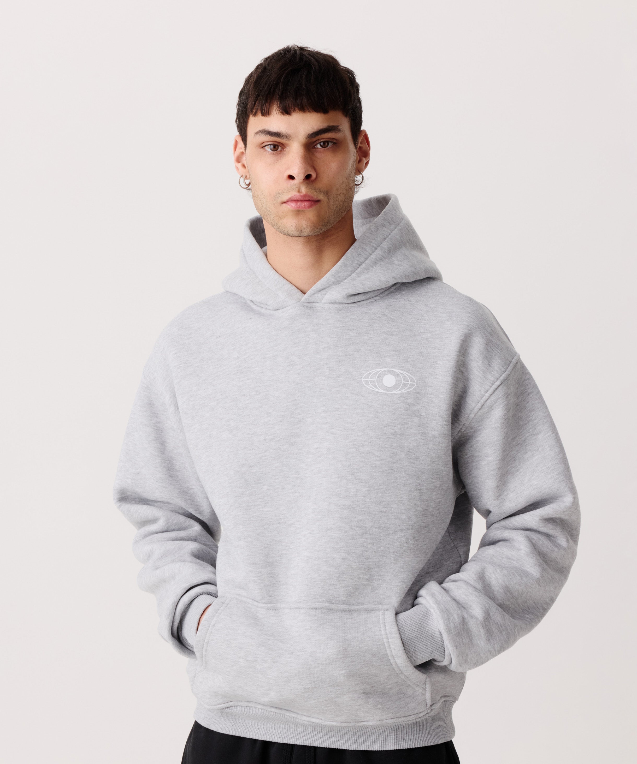 Ein hell-grauer Kapuzen-Pullover getragen von einem Mann. 