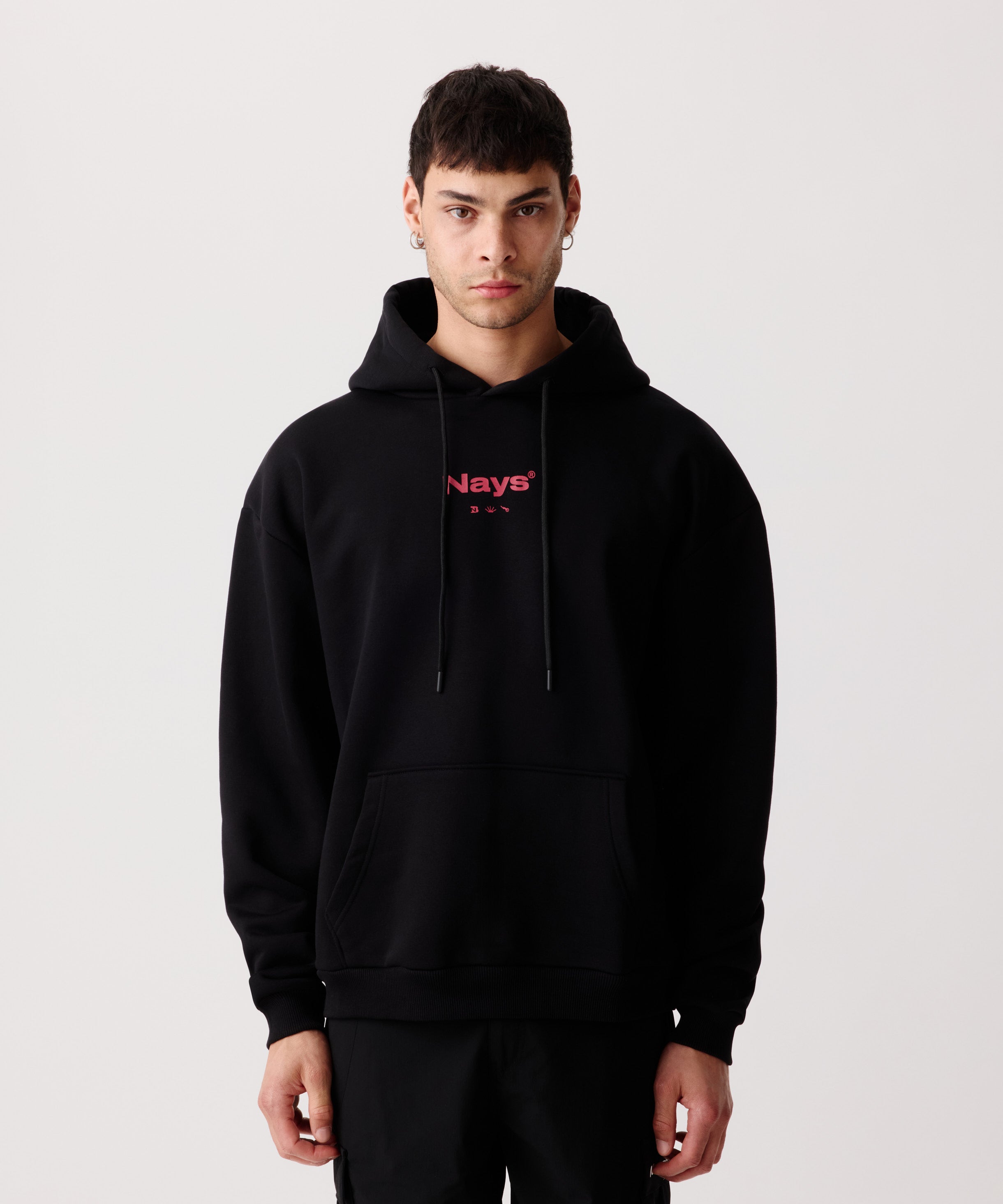 Der Pro Tackle Kapuzen-Pullover getragen von einem Mann. Er trägt dazu eine lange, schwarze Hose.