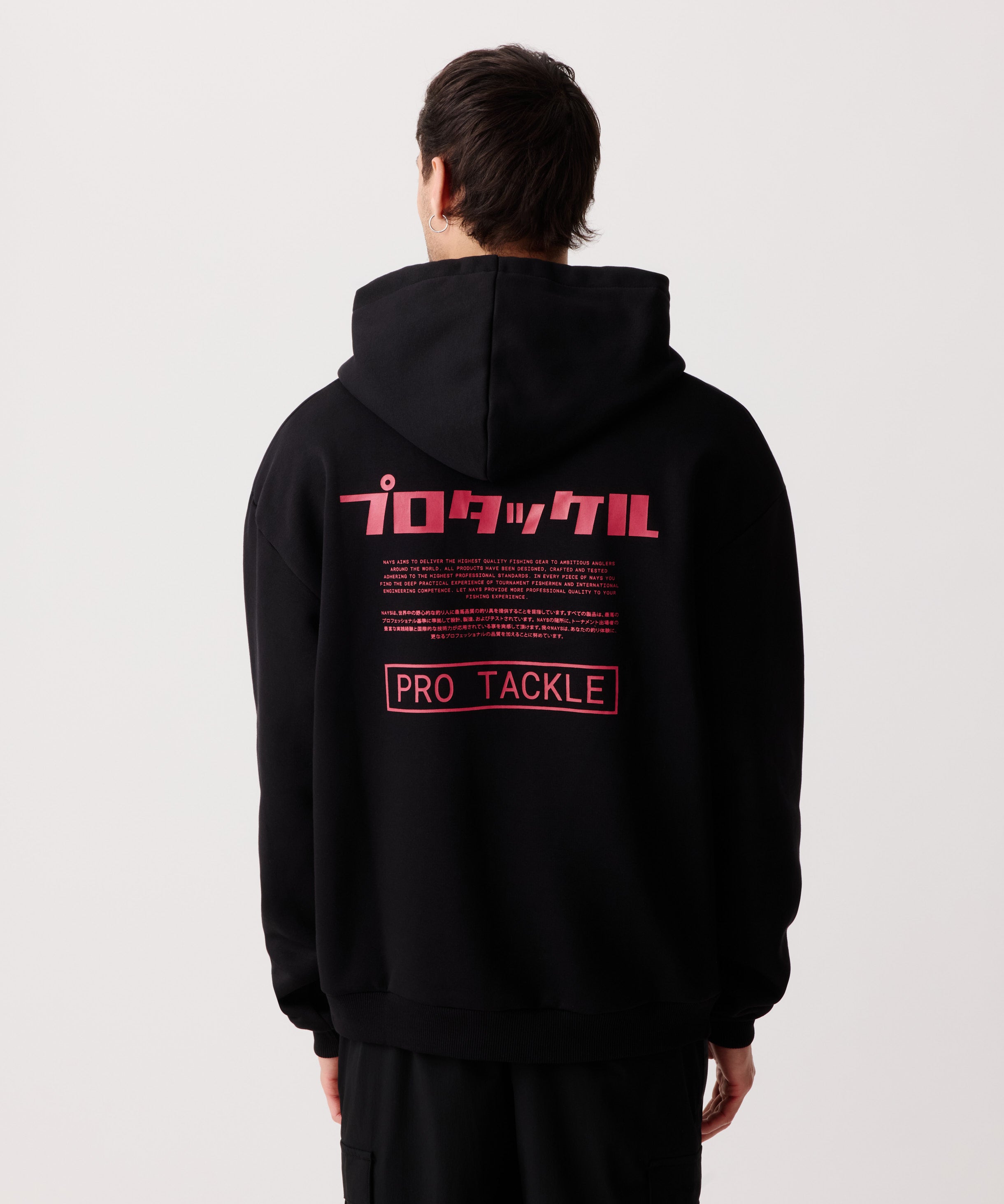 Rückansicht eines Mannes im schwarzen Pro Tackle Kapuzen-Pullover mit gut sichtbaren Logo-Schriftzügen in Englisch und Japanisch.