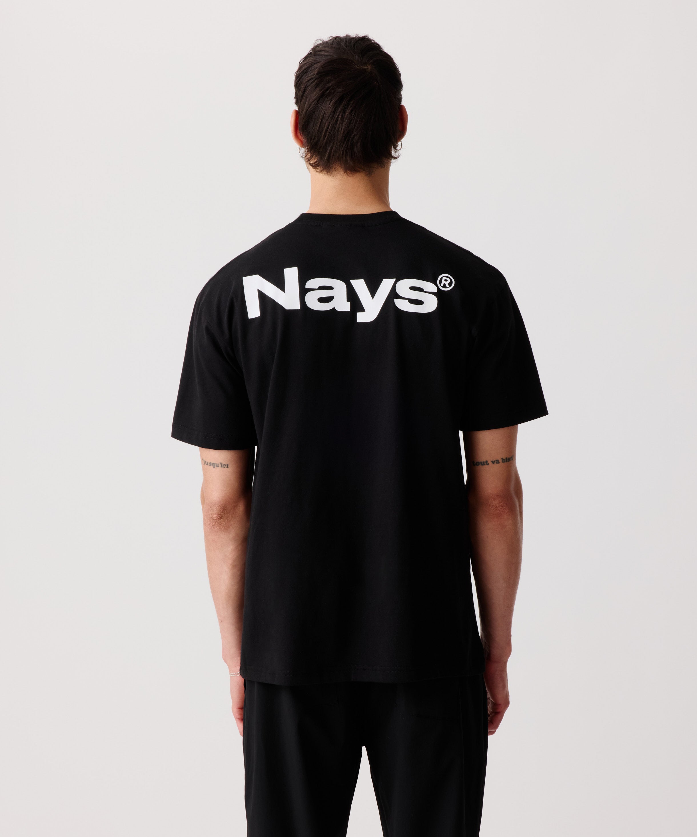Ein Mann trägt unser schwarzes Logo T-Shirt mit Rücken-Print in der Rück-Ansicht.
Deutlich zu erkennen das auffällige, weiße Logo auf den Schultern.