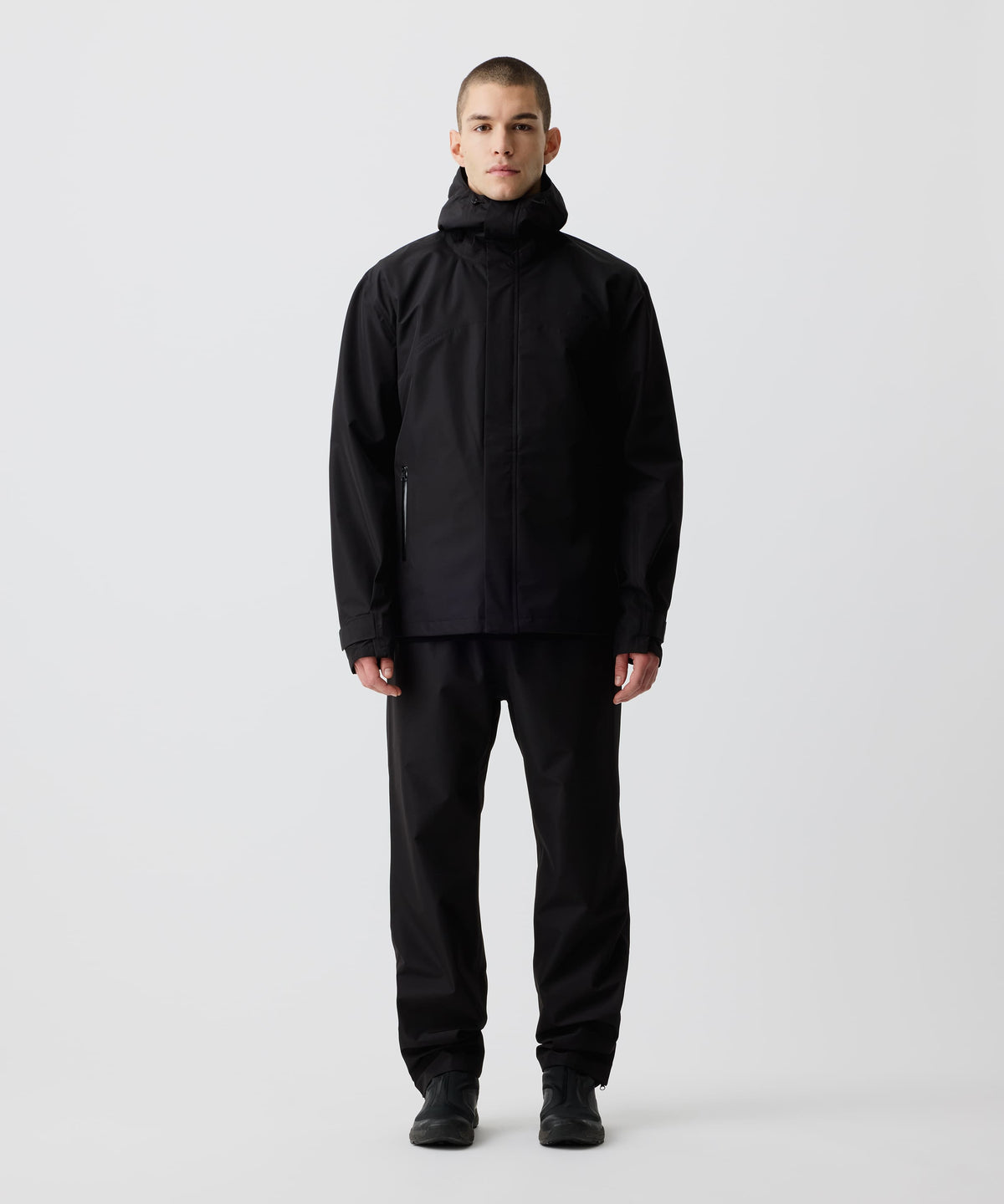 Ein Mann trägt die Nays 3L Multifunctional Rain Jacket in der Frontalansicht, ideal für Outdoor-Abenteuer, mit verstellbarer Kapuze und wasserdichten Reißverschlüssen.