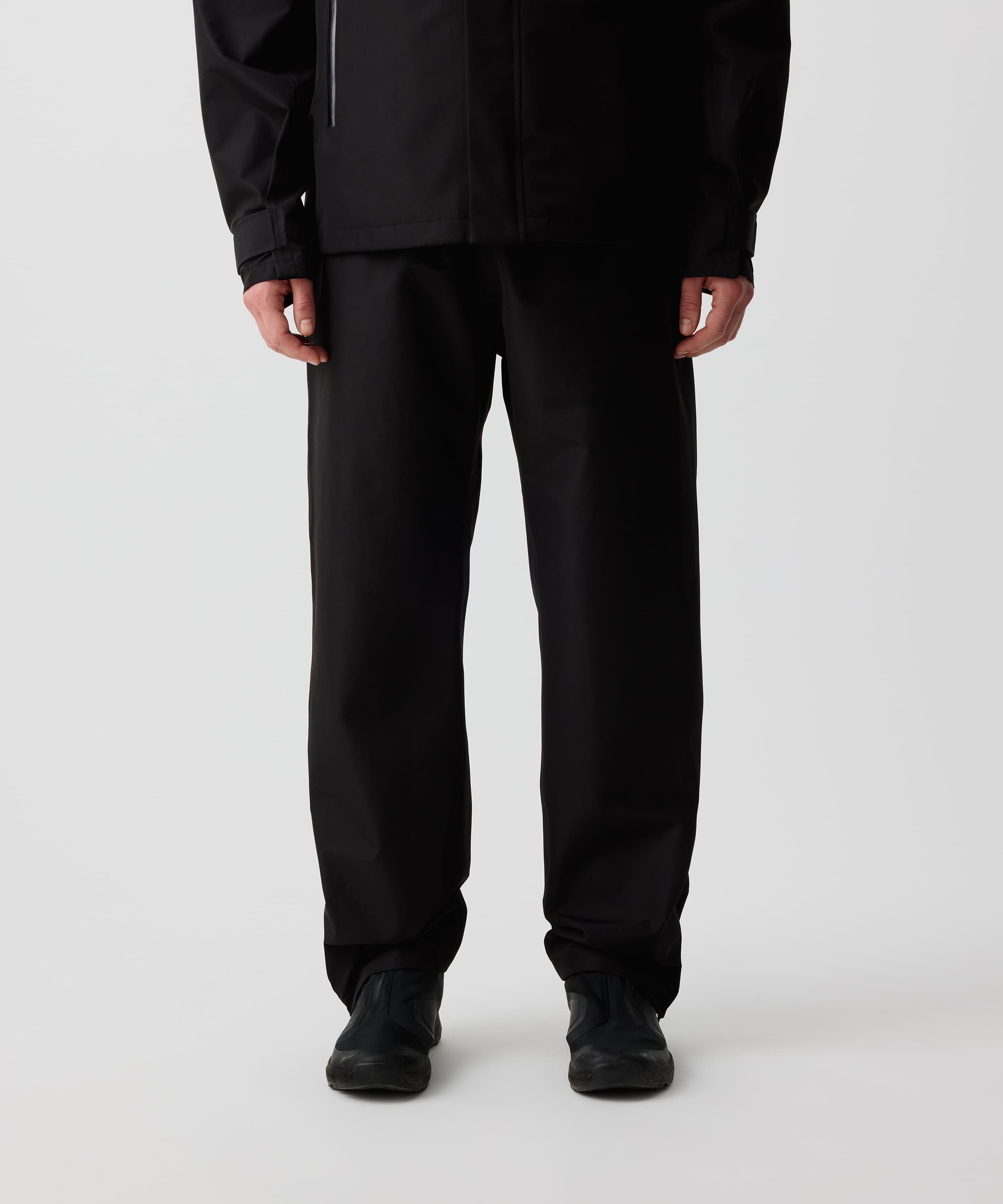 Nays 3L Multifunctional Rain Pants getragen von einer Person, zeigt ergonomische Passform und Reißverschlüsse am Beinsaum für einfaches An- und Ausziehen über Schuhe.
