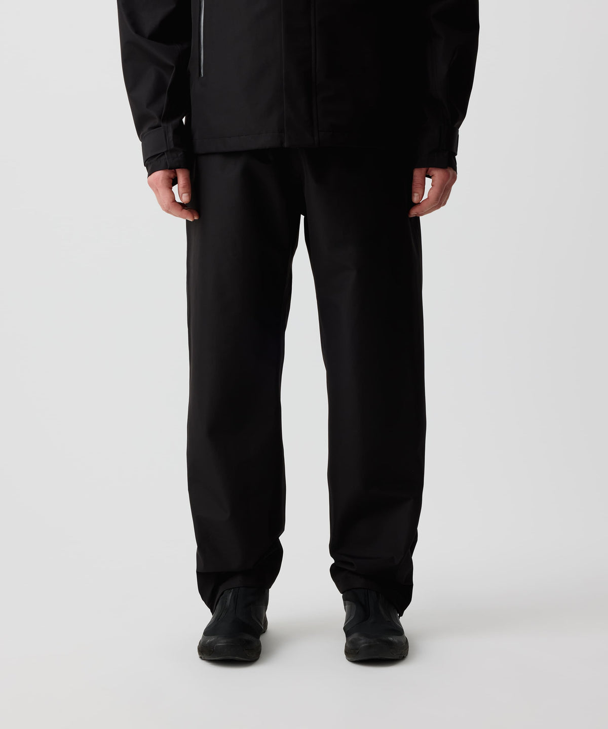 Nays 3L Multifunctional Rain Pants getragen von einer Person, zeigt ergonomische Passform und Reißverschlüsse am Beinsaum für einfaches An- und Ausziehen über Schuhe.