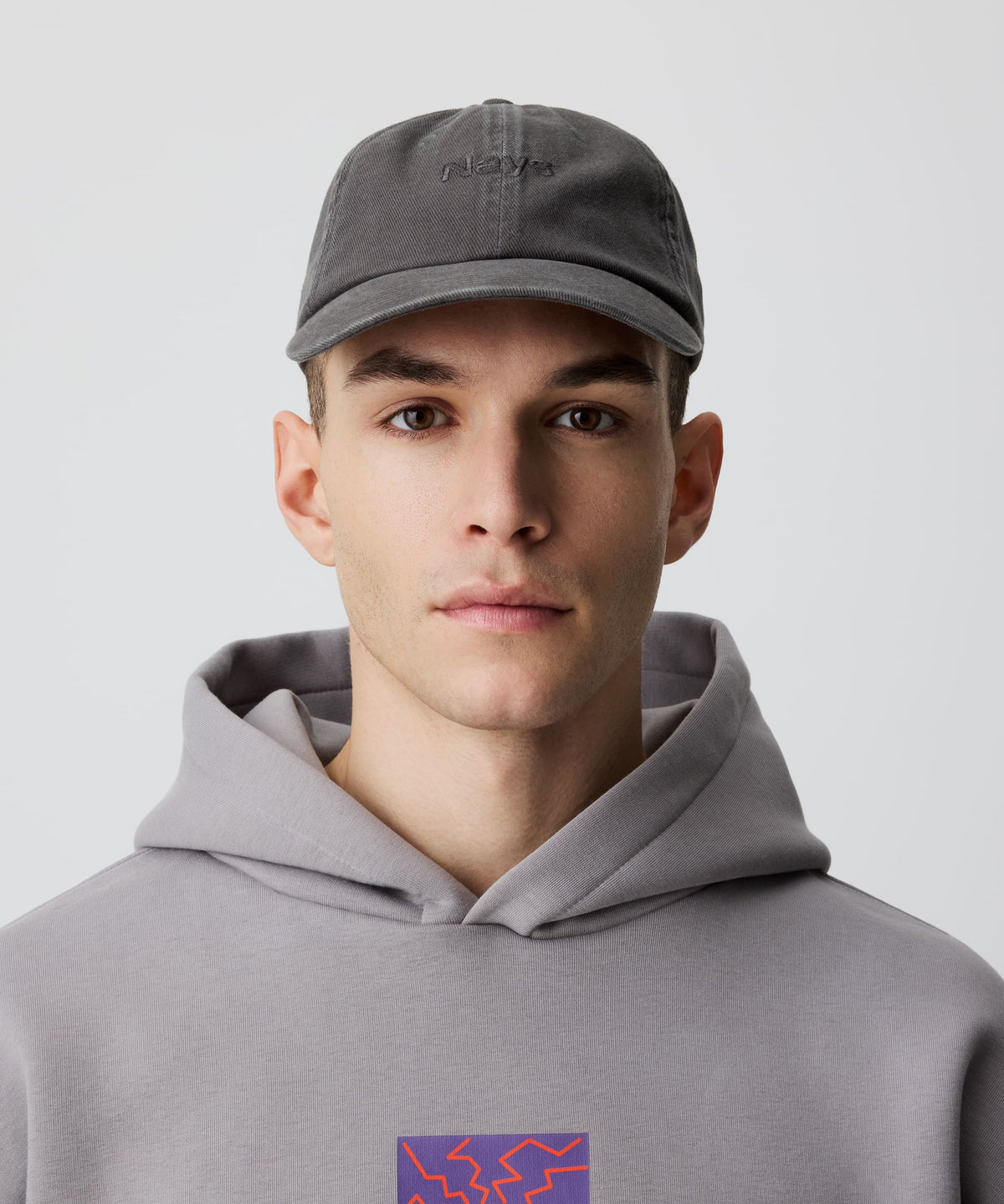 Mann trägt Nays Sports Cap Washed mit charakteristischem Washed-Effekt und verstellbarer Passform, kombiniert mit grauem Hoodie für lässigen, zeitlosen Stil.
