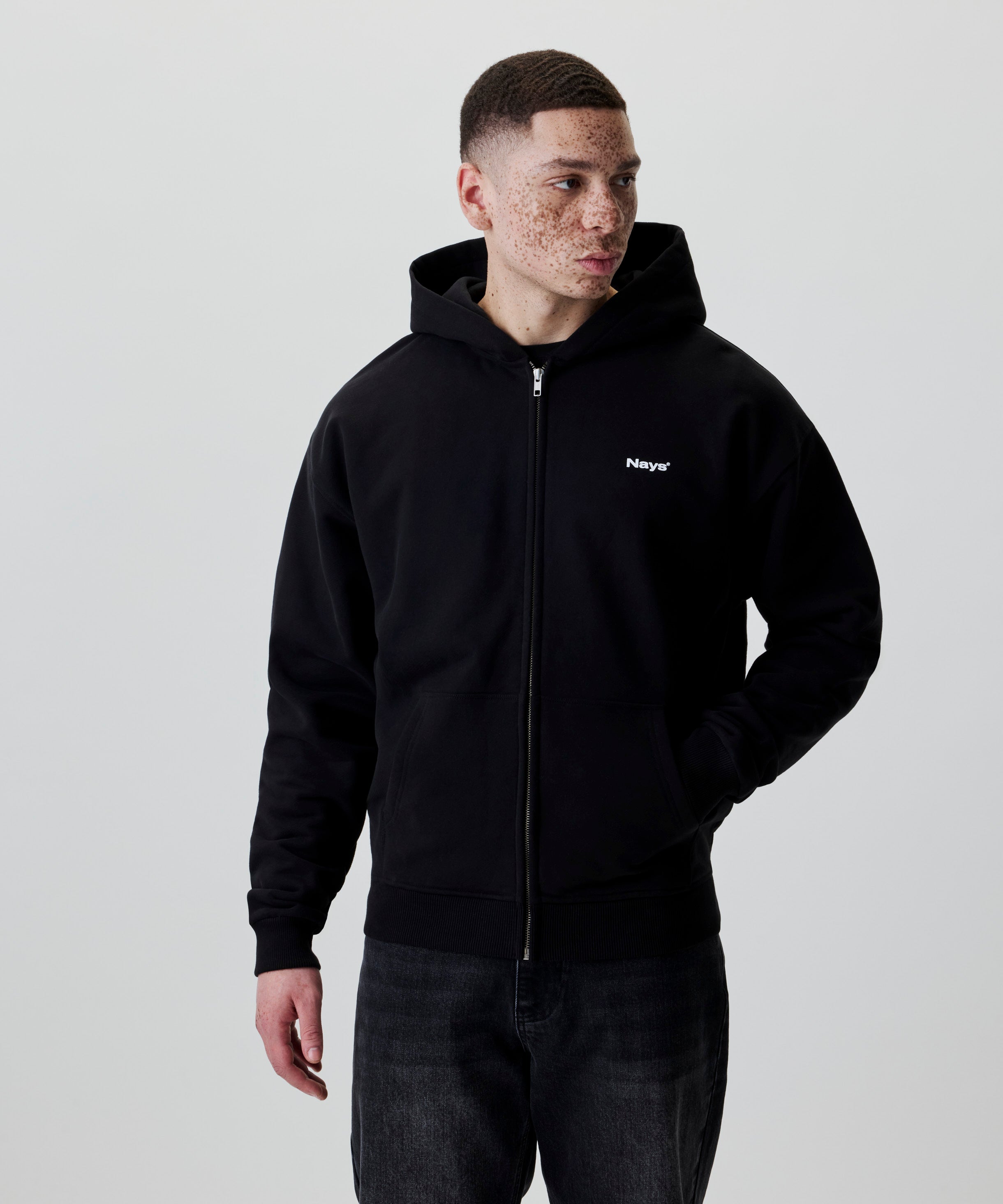 Schwarze Kapuzenjacke mit Nays Logo und Reißverschluss, Seitenansicht.