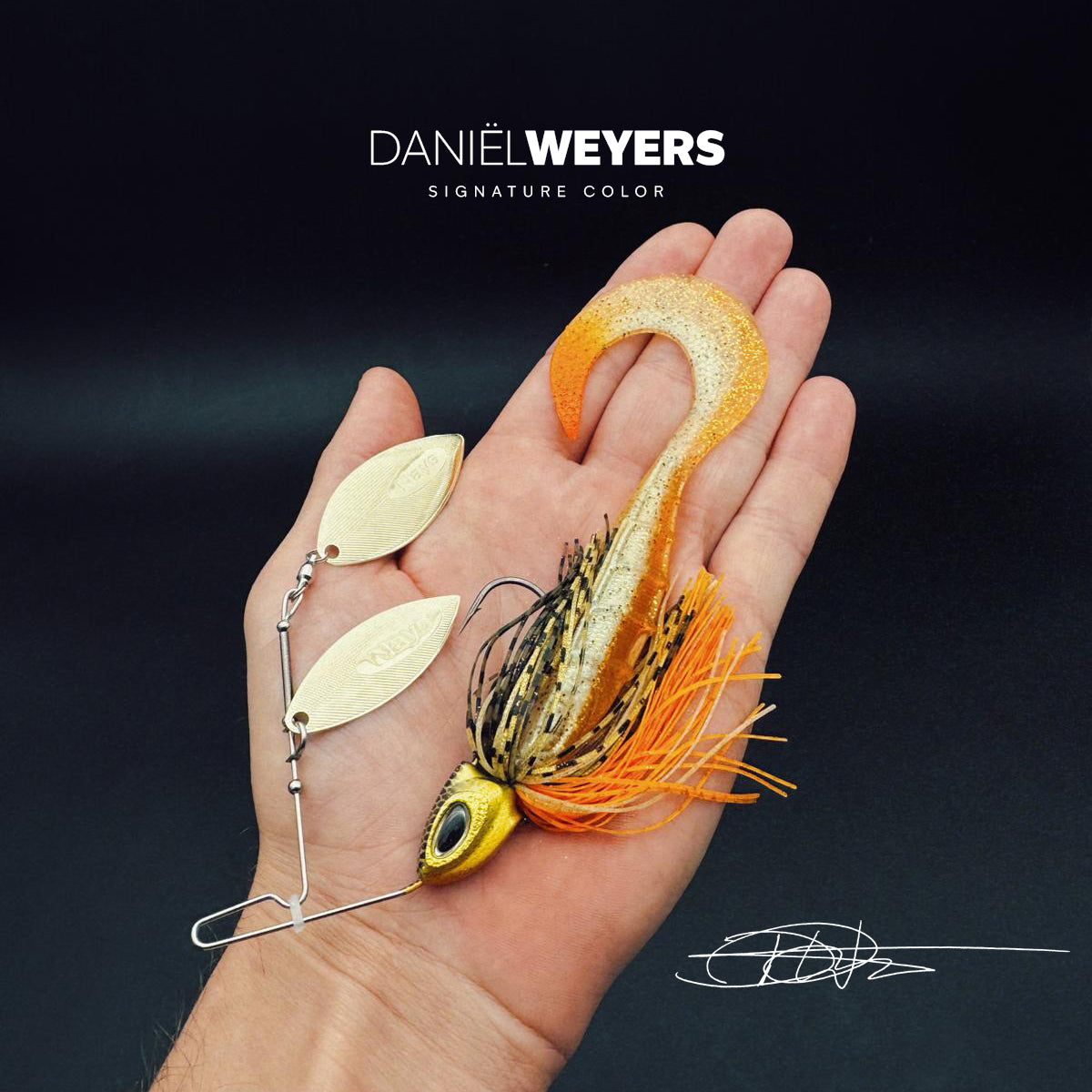 Nays GHST JNR 50 - Daniel Weyers Spinnerbait mit gold-oranger Farbgebung, zwei Willow-Blades, realistischer Jigkopf, orange-schwarzem Rock und aktivem Curly Tail.