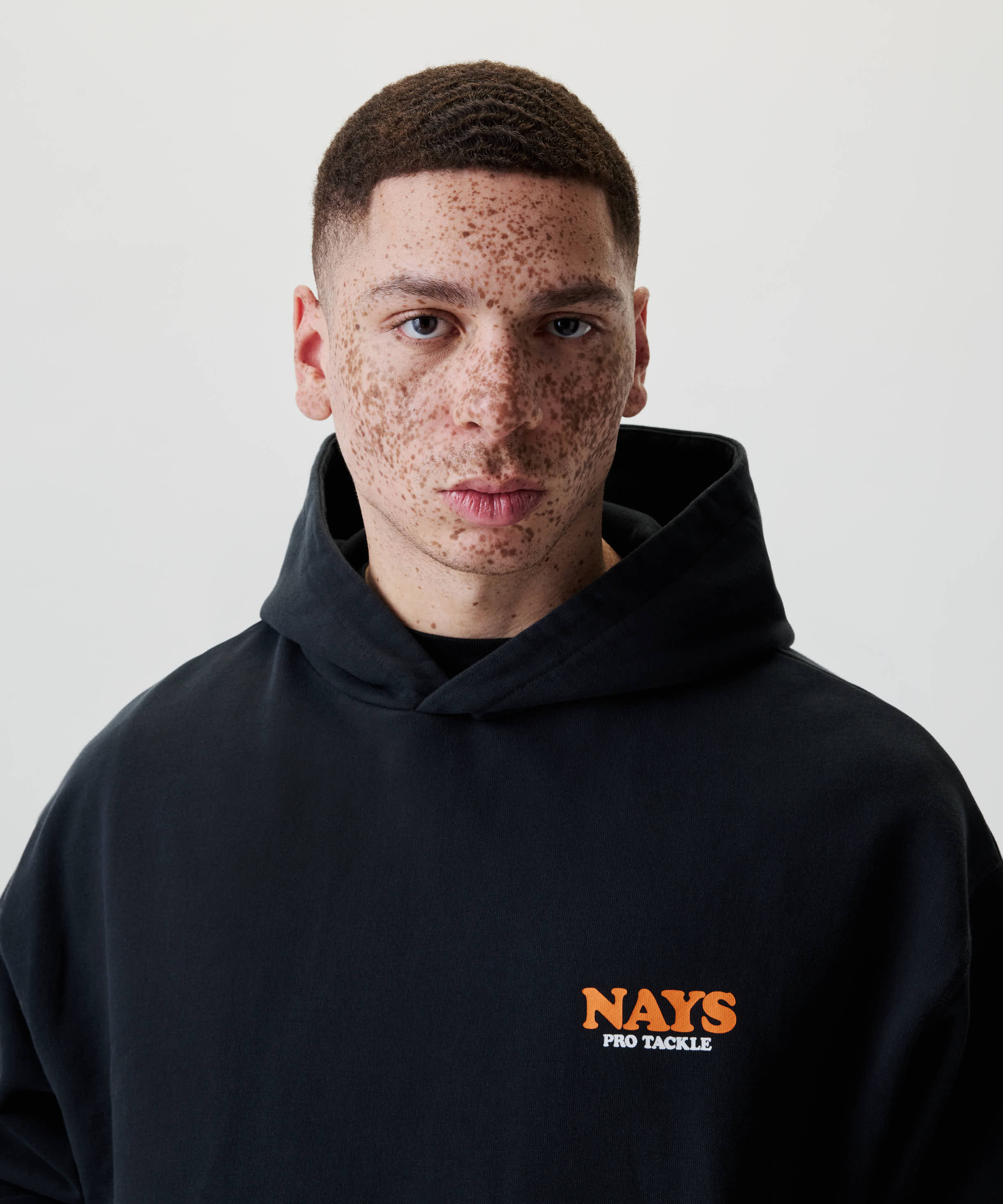 Nays College Print Hoodie mit NAYS und PRO TACKLE Aufdruck, getragen von einem jungen Mann.