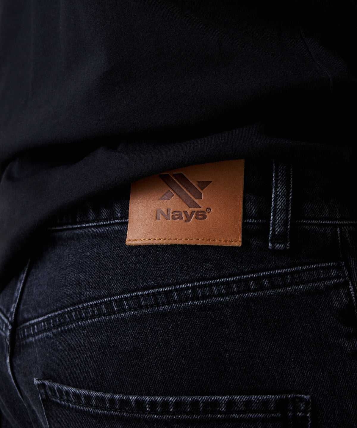 Nahaufnahme der Nays Regular Fit Jeans mit braunem Logo-Patch am Bund, zeigt das klassische 5-Pocket-Design und hochwertige Verarbeitung aus elastischem Denim.