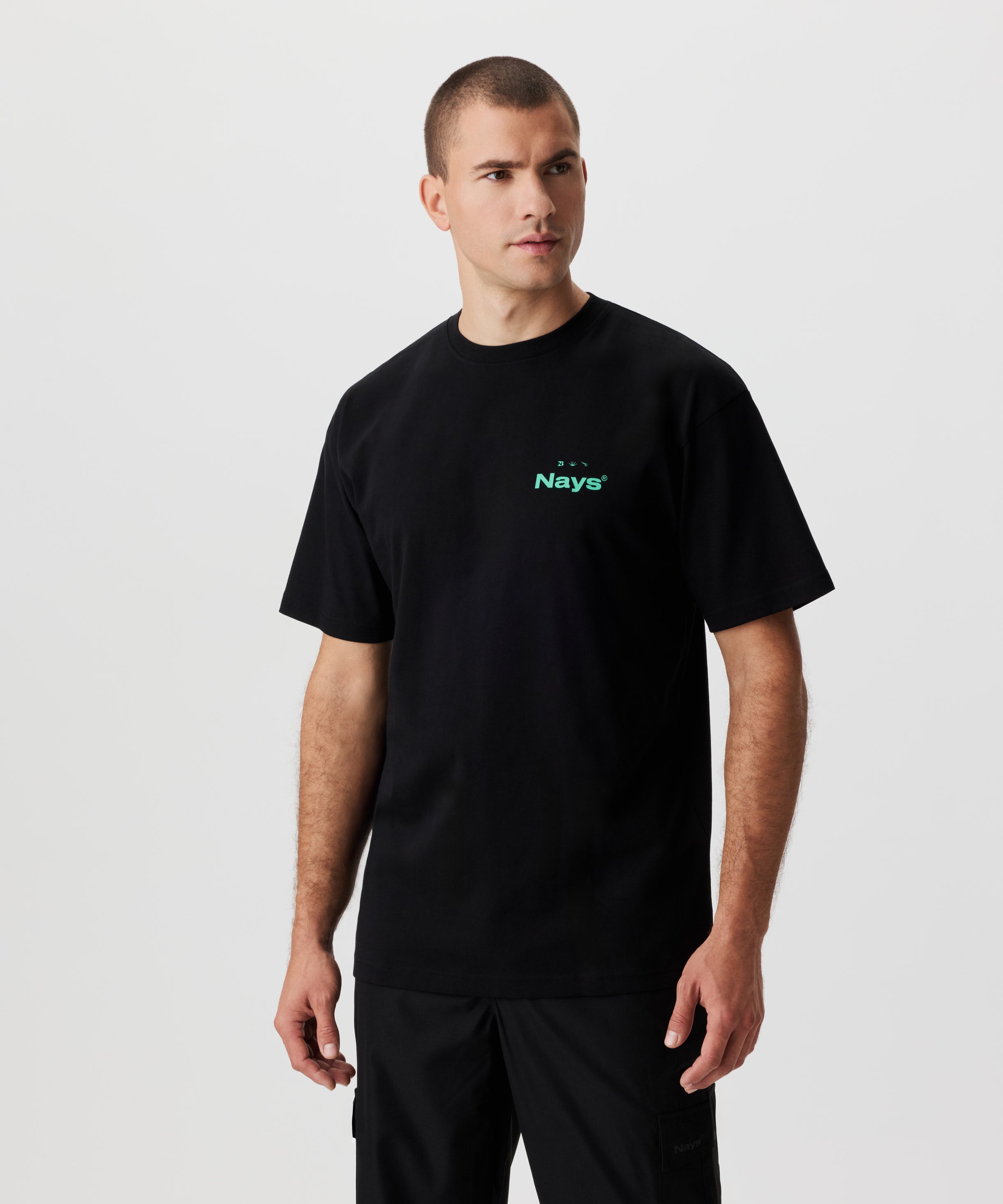 Vorderansicht Mann im schwarzen T-Shirt mit grünem Print auf der Brust.