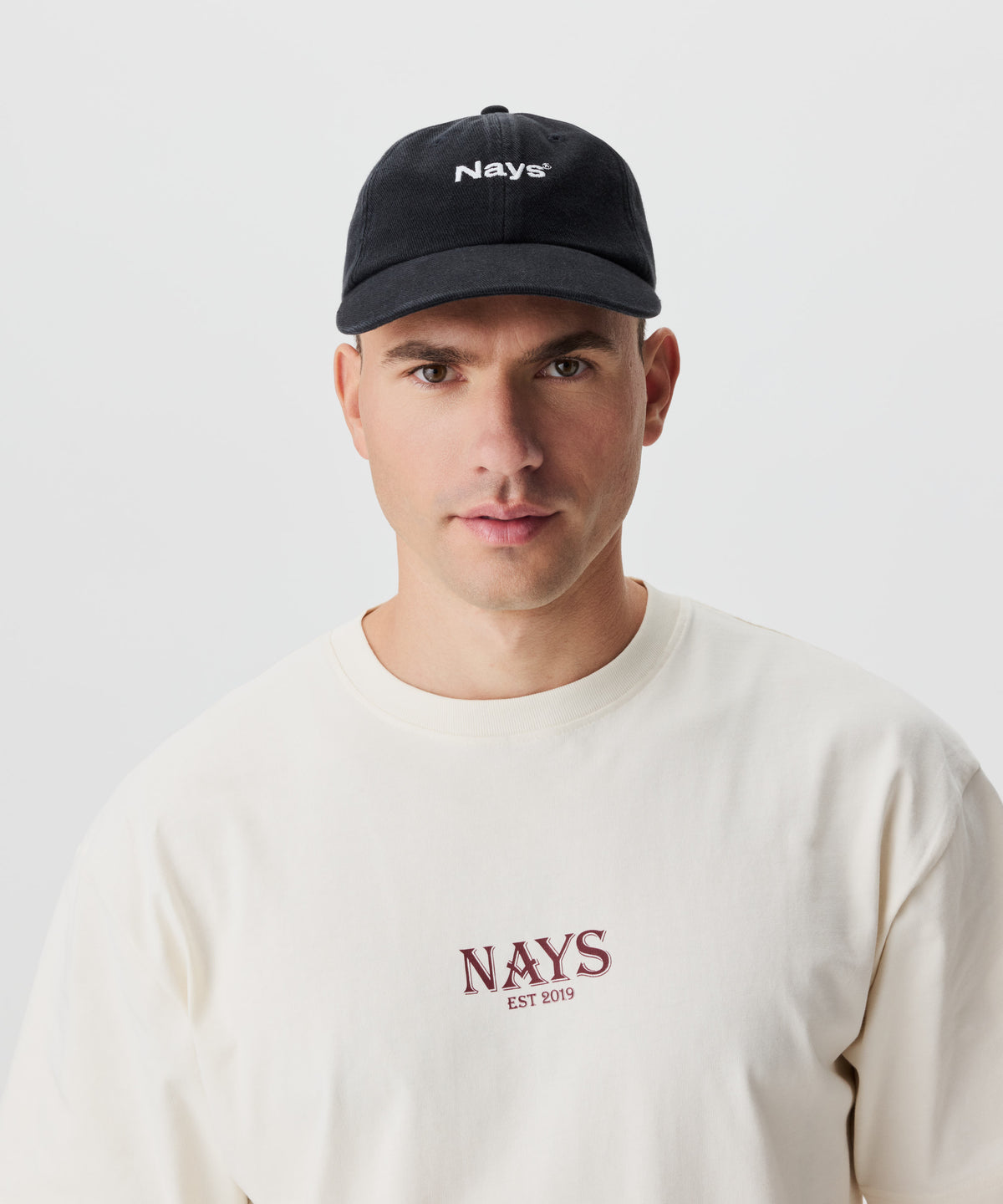 Frontale Ansicht Mann mit dunkelgrauer Cap und Nays-Logo-Schriftzug vorne.