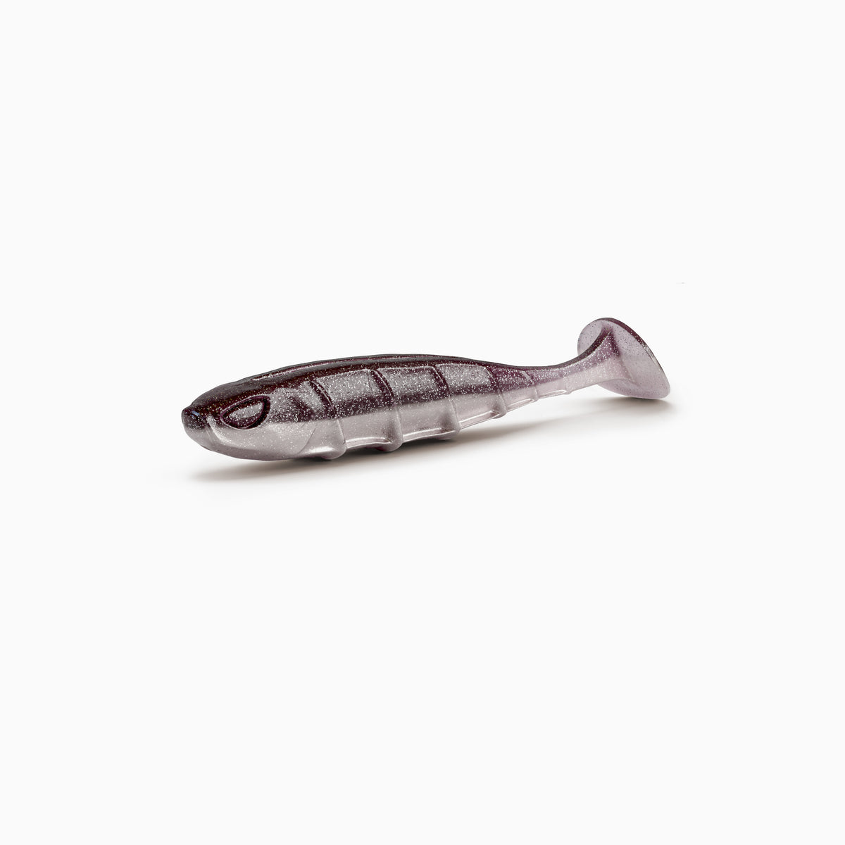 Das Bild zeigt einen Paddle-Tail-Gummiköder mit realistischem Augen-Design, typischer Rippenstruktur und schlankem Körper. Der Körper ist in gedecktem braun-grau gehalten, während der Bauch einen hellgrauen Kontrast mit silbernen Partikeln bildet.